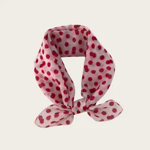 Detail showing soft pink strawberry print scarf with breathable lightweight fabric