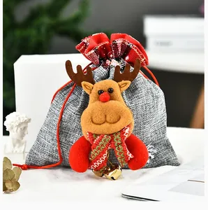 Detalle de la bolsa de regalo de Navidad con un reno de peluche 3D y cascabeles dorados.