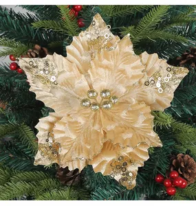 Primer plano de una flor de Navidad artificial de color oro champán con lentejuelas.
