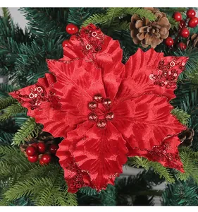 Primer plano de una flor de Navidad artificial roja con lentejuelas en un árbol
