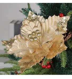 Primer plano de una flor de pascua artificial dorada para árboles de Navidad.