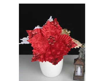 Detalle de flor navideña artificial roja con lentejuelas en un jarrón blanco minimal