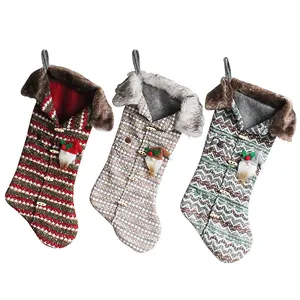 Set of three knitted Christmas stockings with faux fur trim and gnome ornaments