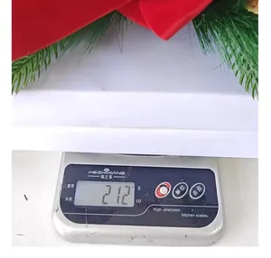 Detail view of a red velvet Christmas wreath weighing 212 grams on a precise digital scale