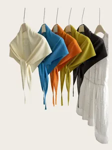 Detailansicht dünner gestrickter Dreieckstücher in verschiedenen kräftigen Farben.