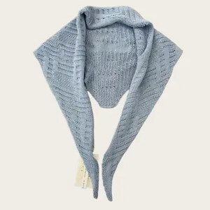 Detailed macro view of elegant light blue knitted hollow triangle shawl scarf for women