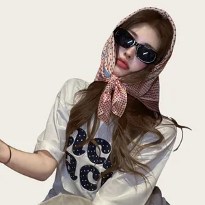 Dettaglio di un foulard a pois stile francese indossato con occhiali per il tempo libero.
