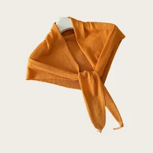 Detailansicht eines leichten orangefarbenen Strick-Dreieckstuchs für Damen, feine Textur.