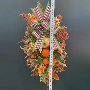 Ghirlanda autunnale del Ringraziamento con zucca e fiocco a scacchi per la porta