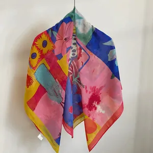 Colorful floral print silk-cotton square scarf hanging on a minimalist white wall