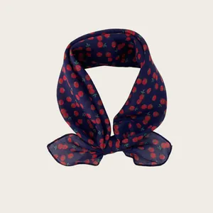 Detailed macro view showing the soft texture and red tomato print of this navy blue scarf