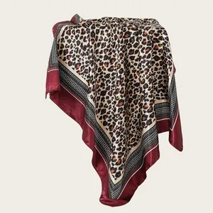 Detailed view of a 90cm leopard print satin square scarf with a wine red border drape.