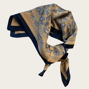 Vintage paisley silk scarf in gold and black, tied in a stylish knot.