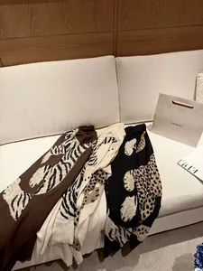 Primer plano de tres bufandas vintage con estampado animal en marrón, crema y negro