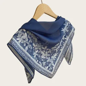 Close-up of elegant blue floral square scarf featuring breathable lightweight fabric