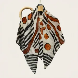 Close-up of the elegant animal print pattern on a high-quality silk cotton square scarf.