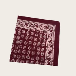 Detail of burgundy block printed cotton scarf with intricate white floral patterns
