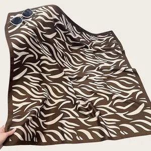 Primo piano del motivo zebrato su sciarpa di seta twill marrone con occhiali