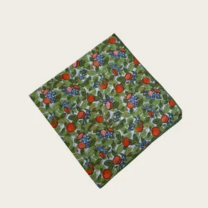 Detail view of orange fruit and blue floral print square silk scarf.