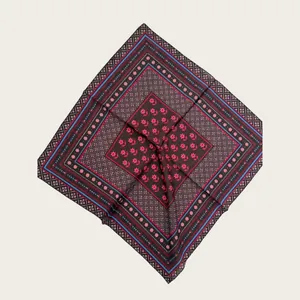 Detailed view of dark brown silk scarf with pink floral and geometric blue border