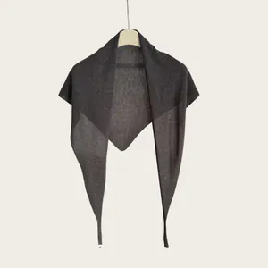 Detailansicht eines leichten, minimalistischen, dunkelgrauen gestrickten Dreieckstuchs.