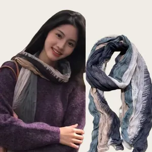 Detailed view of a lightweight pleated cotton-linen scarf featuring blue and beige tones