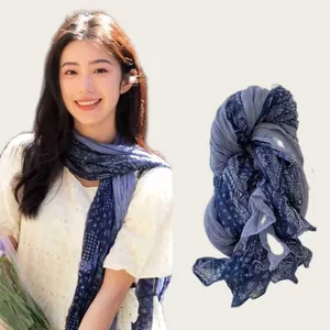 Close-up detail of the bohemian blue floral pattern and wrinkled texture on a cotton linen scarf
