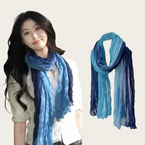 Detailed view of long blue gradient wrinkled cotton linen scarf on an Asian model