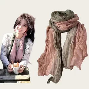 Detail of literary crinkled cotton linen scarf in olive and rose gradient
