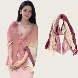 Detail view of a pink pleated cotton-linen scarf worn as a shawl by a model