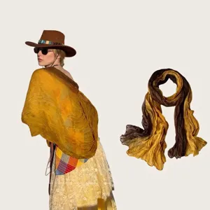Detailed view of a pleated cotton-linen scarf in yellow and brown gradient tones.