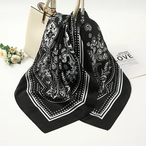 Detailed look at elegant black and white paisley pattern on satin silk square scarf