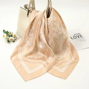 Elegant 90cm beige satin square scarf with white paisley patterns displayed on a handbag