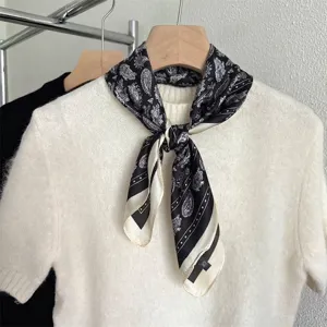 Vista dettagliata di un foulard di seta con motivo paisley retrò francese su maglione bianco