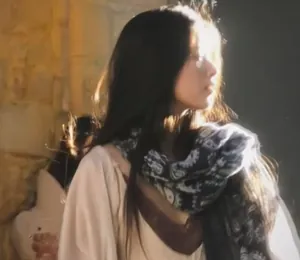 Bohemian paisley pattern travel scarf shawl shown on a model in warm sunlight.