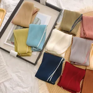 Verscheidenheid aan geplooide effen zijden sjaals in verschillende kleuren voor styling