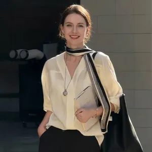 Femme élégante portant un long foulard rayé noir et blanc avec un chemisier en soie