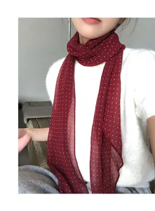Dettaglio ravvicinato della sciarpa di seta bordeaux a pois con design vintage
