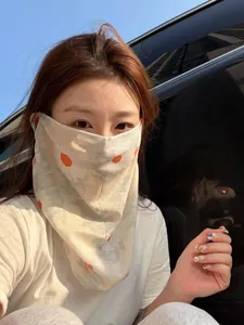 Femme en extérieur portant un masque de protection solaire en soie glacée à fleurs