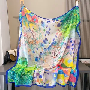 Vista detallada de un gran pañuelo de seda cuadrado con un vibrante estampado floral artístico