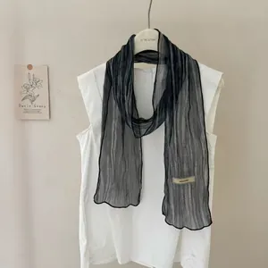 Lightweight tie-dye striped long scarf with black piped edges on a white shirt