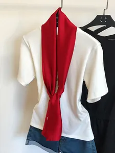 Écharpe étroite en soie rouge vif élégante sur un t-shirt décontracté blanc tendance