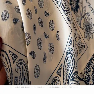 Close-up detail of breathable silk-like scarf with blue paisley and floral patterns