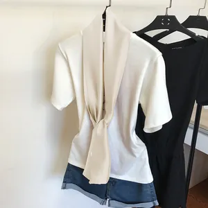 Élégant foulard étroit en soie crème stylisé avec un t-shirt blanc pour un look chic
