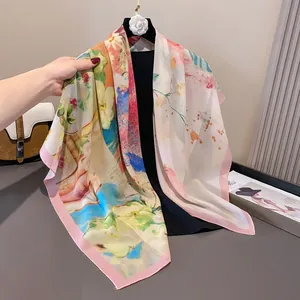 Detalle del elegante estampado floral en un pañuelo cuadrado de gasa de raso 110x110cm