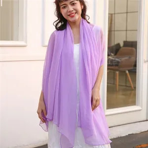 Detailed view of a lightweight purple gauze sun protection shawl worn by a model