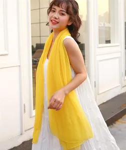 Detailed view of lightweight yellow sun protection shawl worn by model outdoors