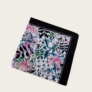 Close-up detail of a square silk scarf with elegant pink floral and leopard prints