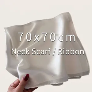 Close-up detail showing the smooth satin texture of a cream white 70x70cm silk scarf