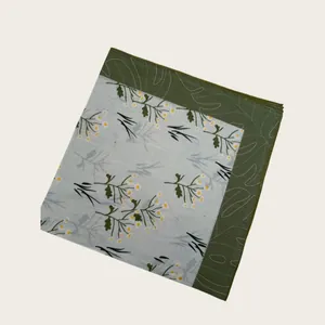 Detail view of light blue scarf with daisy floral print and green leaf border